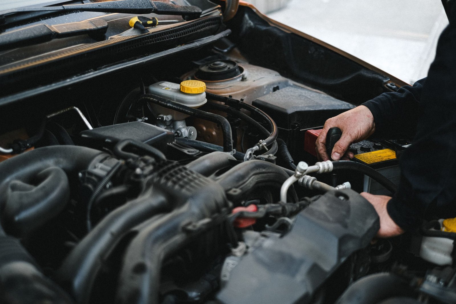 Mechanic repairing a car engine at Payless Transmissions in Fort Worth, TX